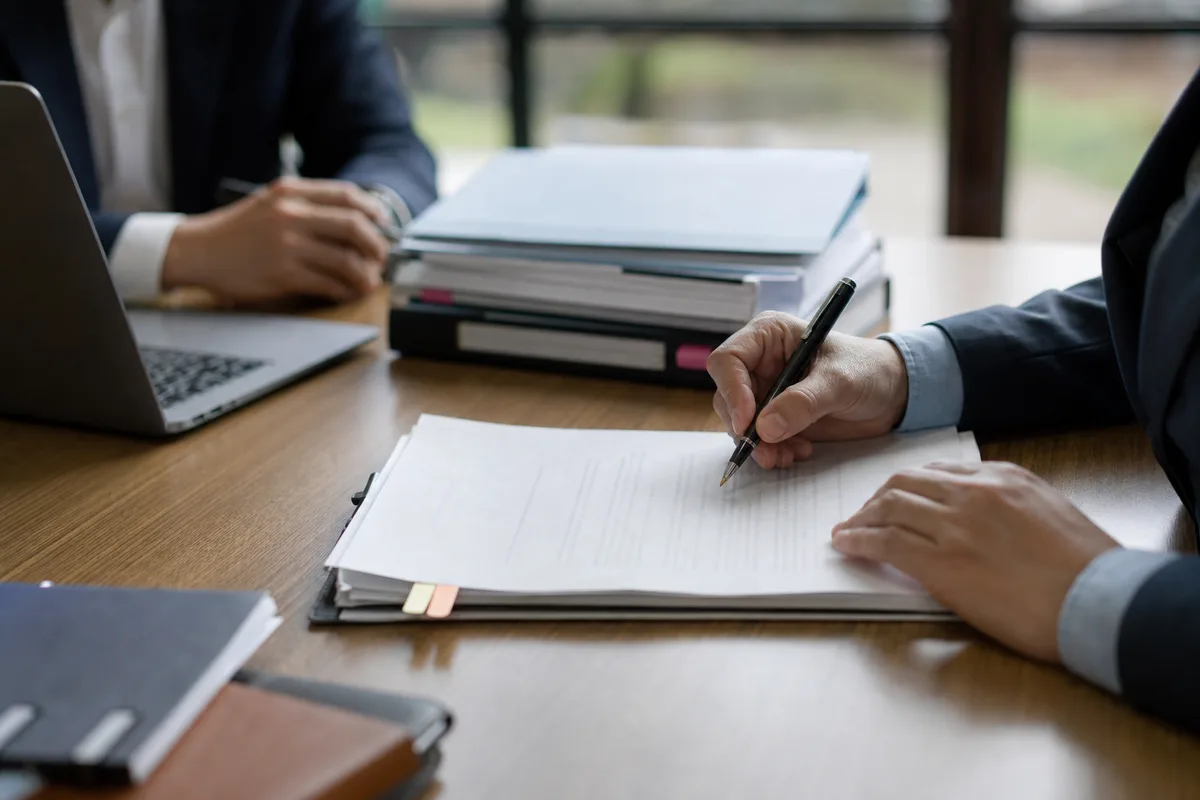 Réunion entre un expert-comptable et une dirigeante de TPE autour de documents sociaux